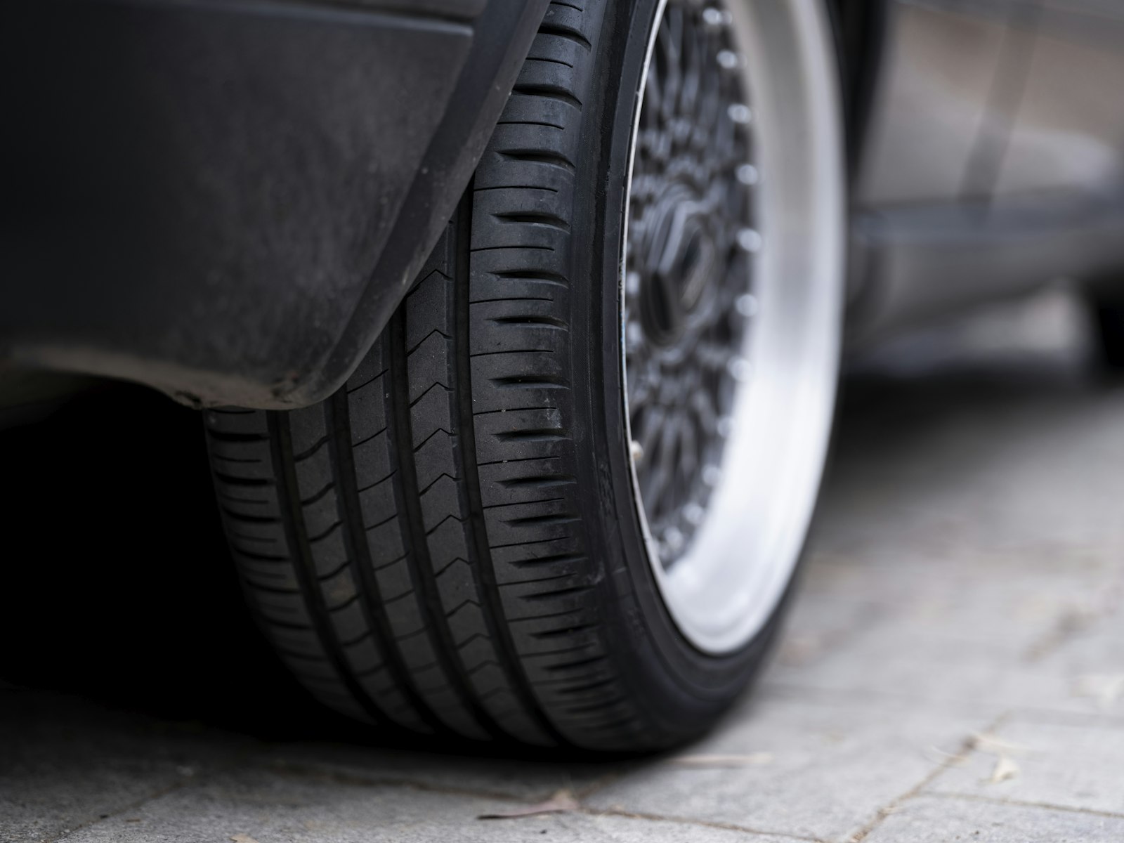 Close-up of a fitted vehicle tyre and alloy wheel in daylight